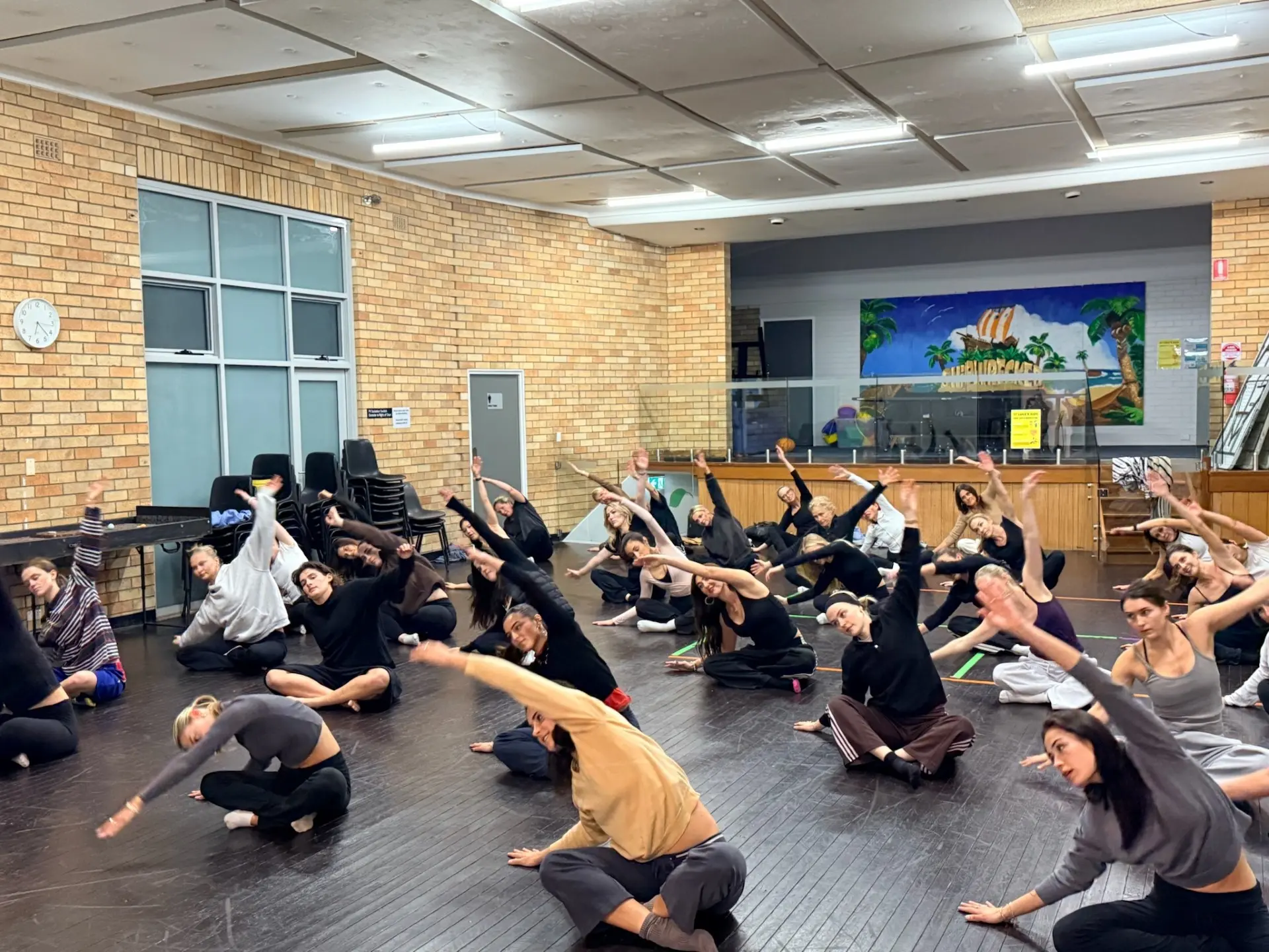 NoCo Movement dancers stretching together in a Sydney community hall